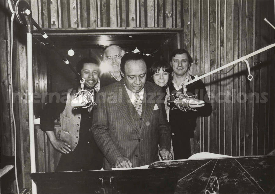 8 x 10 inch photograph. Lionel Hampton playing the vibraphone observed by unidentified persons