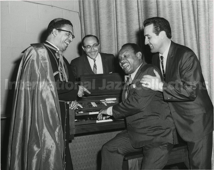 8 x 10 inch photograph. Lionel Hampton with unidentified men including a religious