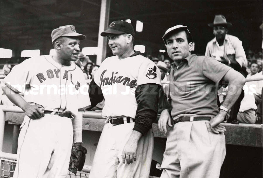 5 x 7 inch photograph. Lionel Hampton in a Kansas City Royals uniform talks to a player of the Cleveland Indians and an unidentified man