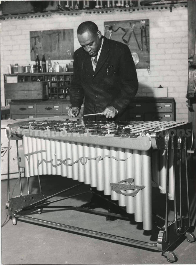 8 1/2 x 6 1/4 inch photograph. Lionel Hampton playing a Trixon vibraphone in a work shop [in Germany]