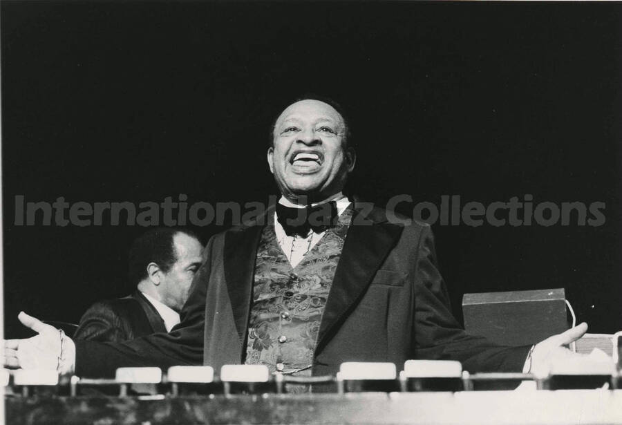 8 x 10 inch photograph. Lionel Hampton standing behind his vibraphone at a concert