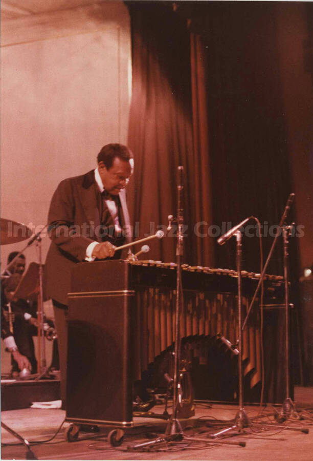 7 x 5 inch photograph. Lionel Hampton  on vibraphone with band. Handwritten on the back of the photograph: Teatro El Circulo, Rosario, Argentina; Lionel Hampton All Stars. This photograph has a dedication from Wis Contijoch and Ruben Gonzalez