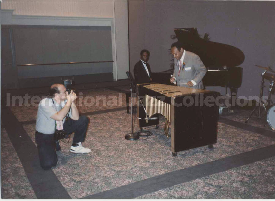 3 1/2 x 5 inch photograph. Lionel Hampton playing the vibraphone observed by an unidentified pianist as a photographer takes his picture, on the occasion of the Republican National Convention, in New Orleans, LA
