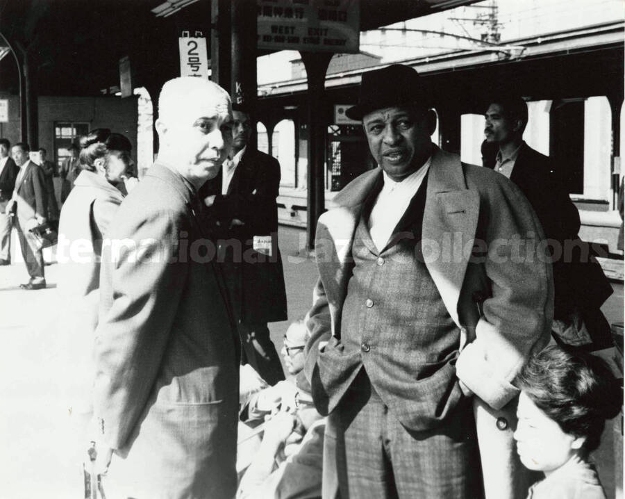 7 1/2 x 9 1/2 inch photograph. Lionel Hampton, Gladys Hampton, and Leo Moore on a train station [in Japan]