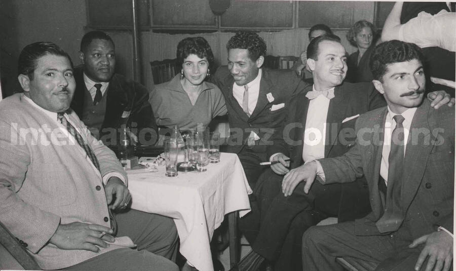 5 x 8 inch photograph. Curley Hamner with unidentified persons in a restaurant in Israel