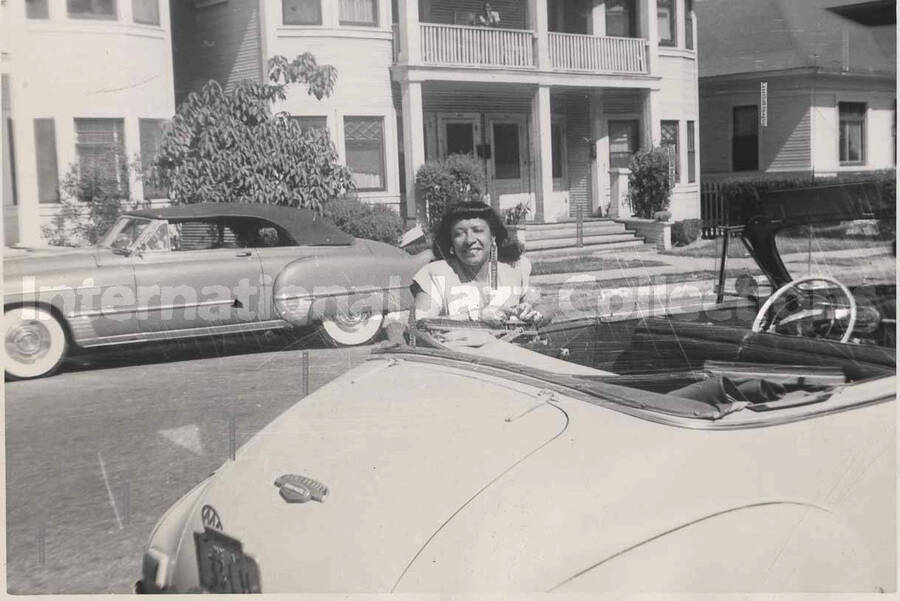 3 x 4 1/2 inch photograph. Gladys Hampton standing next to a car