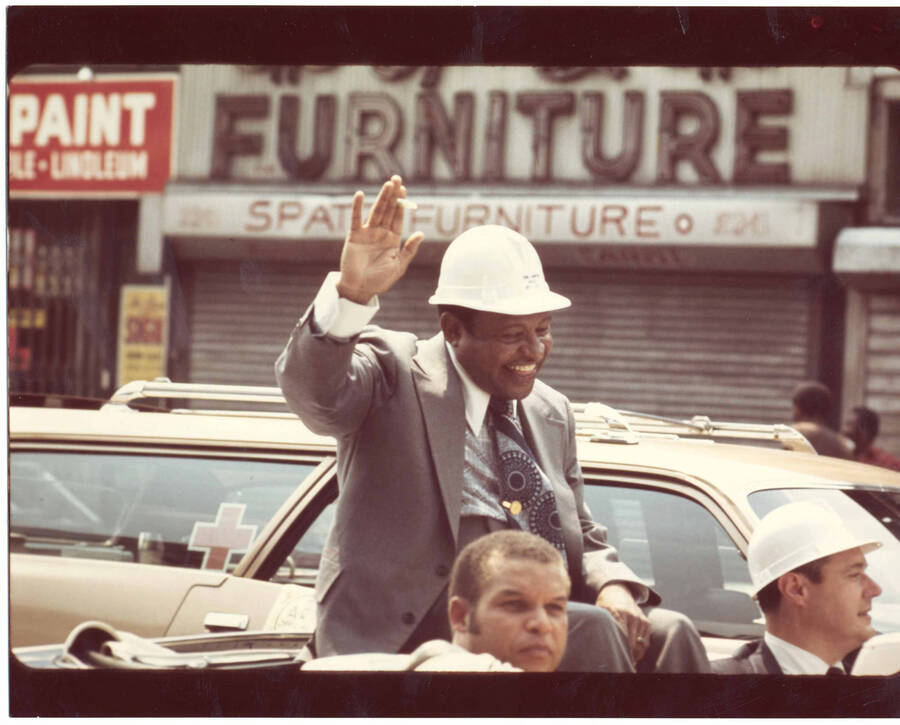 8 x 10 inch photograph. Lionel Hampton sitting in the back of a car waving to the crowd at the Grand Opening of Lionel Hampton Houses