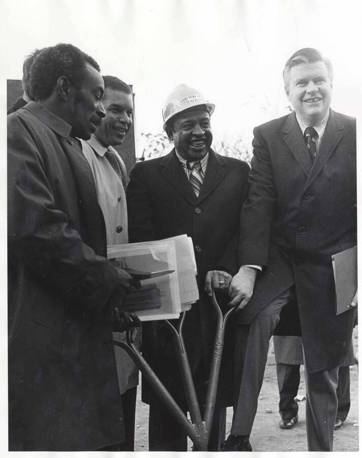 10 x 8 inch photograph. Lionel Hampon with unidentified men holding a shovel with three handles at the ground breaking ceremony of the Lionel Hampton Houses