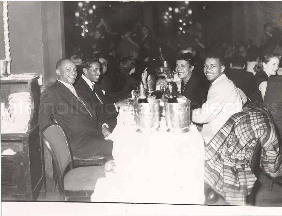 7 x 9 1/2 inch photograph. Lionel Hampton, Curley Hamner, Gladys Hampton, and Leo Moore. Accompanying this photograph is a portfolio from the Lido Cabaret, in the Champs Elysees, Paris, France