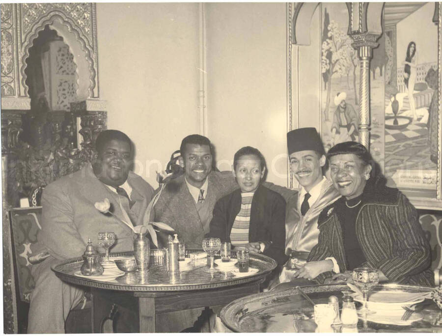 7 x 9 1/2 inch photograph. Gladys Hampton and Leo Moore with unidentified persons. Accompanying this photograph is a portfolio from Cabaret el djazair, in Paris, France