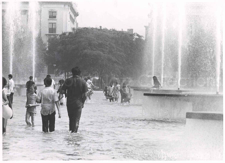8 x 10 inch photograph. Unidentified persons playing in a fountain during Lionel Hampton's outdoor concert