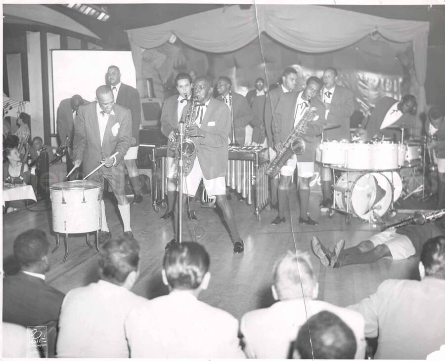 8 x 10 inch photograph. Lionel Hampton on drums with band, in a restaurant