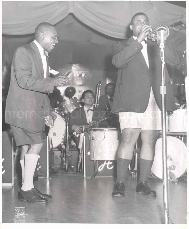 10 x 8 inch photograph. Lionel Hampton with unidentified trumpetist, in a restaurant
