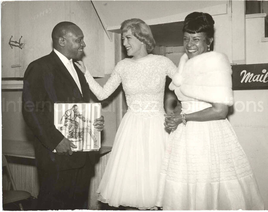 8 x 10 inch photograph. Gladys and Lionel Hampton with unidentified woman. Lionel Hampton is holding the LP Hamp, The Stomping Hamp (Glad-Hamp Records)