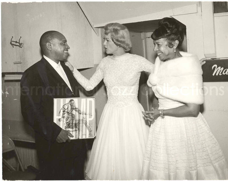8 x 10 inch photograph. Gladys and Lionel Hampton with unidentified woman. Lionel Hampton is holding the LP Hamp, The Stomping Hamp (Glad-Hamp Records)