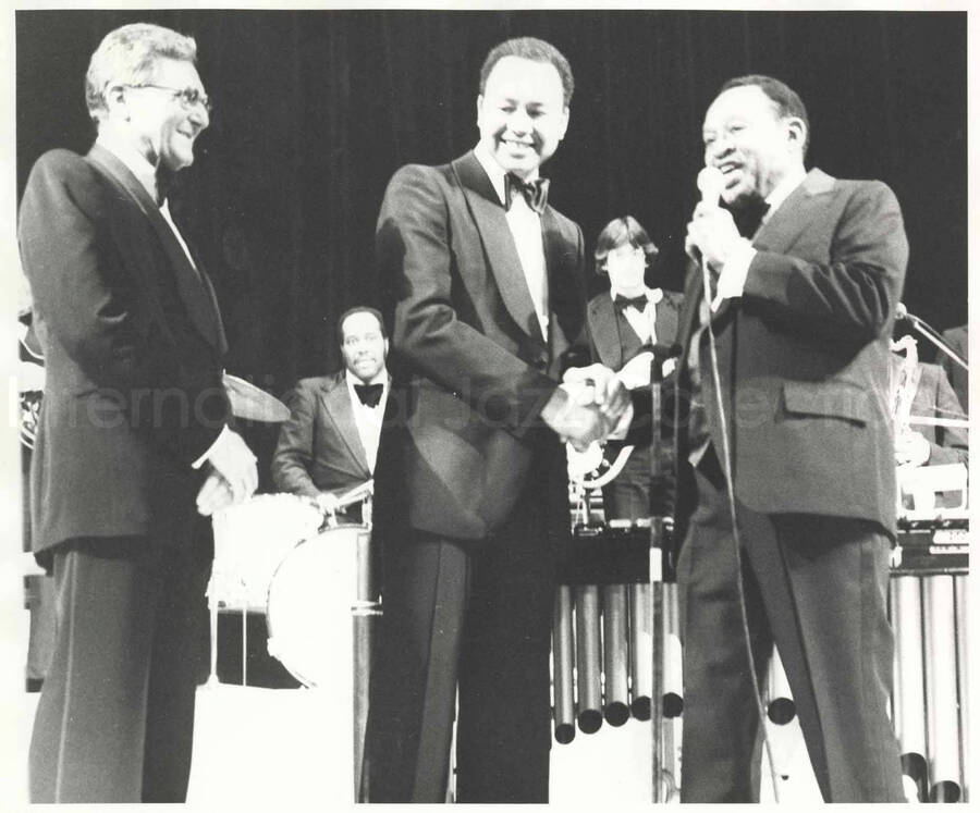 8 x 10 inch photograph. Lionel Hampton on stage with two unidentified men [on the occasion of his receiving a medal]