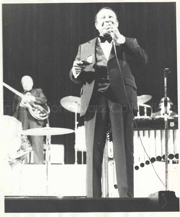 10 x 8 inch photograph. Lionel Hampton on stage holding a box, probably containing a medal
