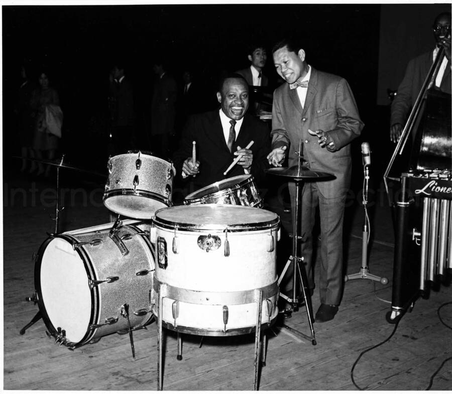 8 x 9 inch photograph. Lionel Hampton on drums with unidentified man [in Japan?]