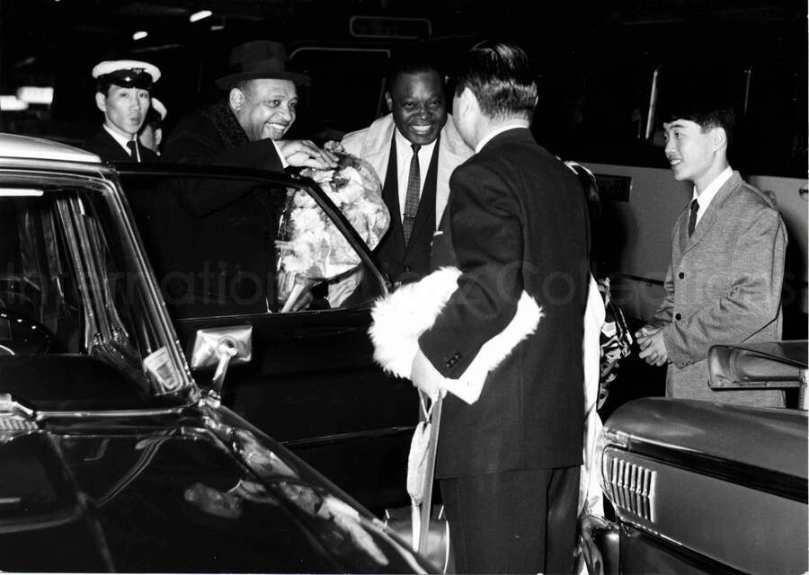 4 1/2 x 6 1/2 inch photograph. Lionel Hampton is welcomed at an airport terminal [in Japan]
