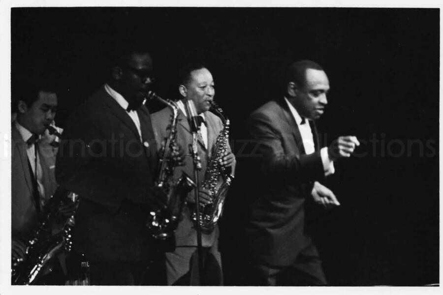 3 x 5 inch photograph. Lionel Hampton on stage with band playing in the background [in Japan?]