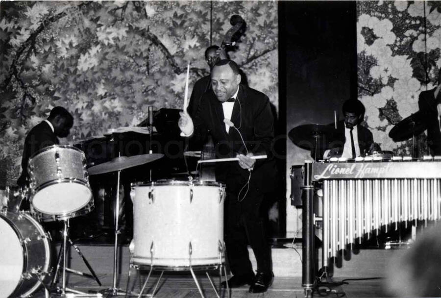 3 x 4 1/2 inch photograph. Lionel Hampton playing the drums with band, in Osaka, Japan