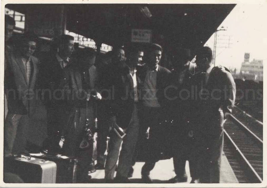 2 1/2 x 3 1/2 inch photograph. Members of the Lionel Hampton's band on a train station [in Japan]