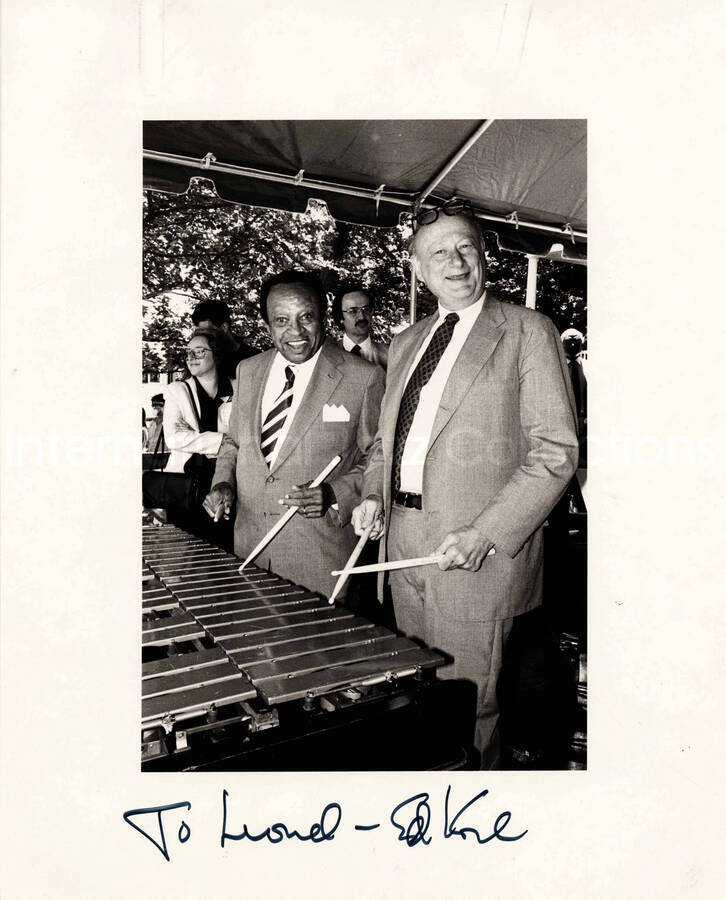 10 x 8 inch photograph. Lionel Hampton with Edward I. Koch, Mayor of the City of New York playing the vibraphone, at the kick-off of the JVC Jazz Festival. New York, NY. Accompanying this photograph is a letter from the photographer to Chuck Jones, dated from August 4, 1988, and a newspaper clipping