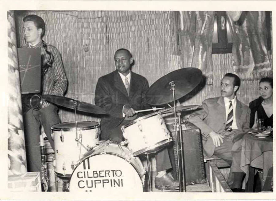 Lionel Hampton playing the drums in Italy. Inscribed on the drums: Gilberto Cuppini. Handwritten on the back of the photograph: Gianni - Basso