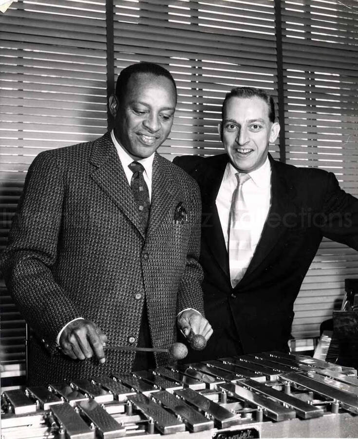 7 1/2 x 6 inch photograph. Lionel Hampton playing the vibraphone with unidentified man