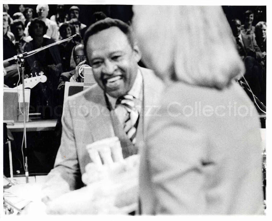 8 x 10 inch photograph. Lionel Hampton presented with a birthday cake by an unidentified woman