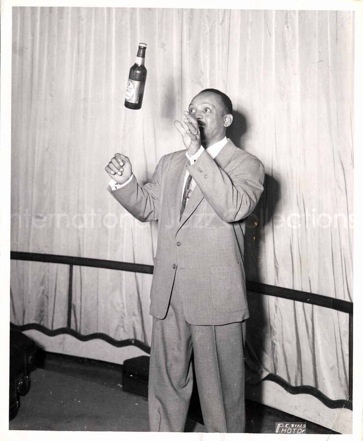 10 x 8 inch photograph. Lionel Hampton tossing a bottle of Patrick Henry beer
