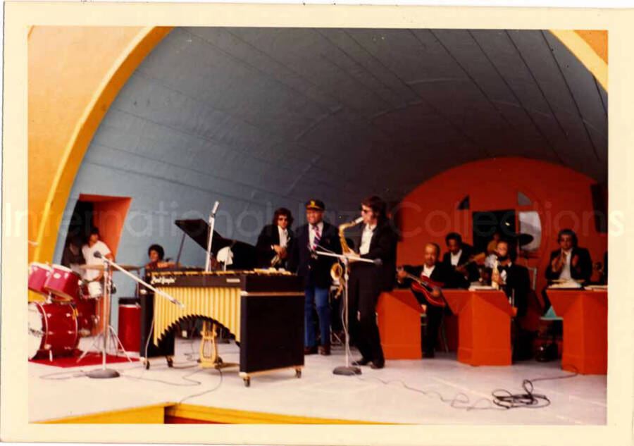 3 1/2 x 5 inch photograph. Lionel Hampton and band, which includes guitarist Billy Mackel, at an outdoor concert