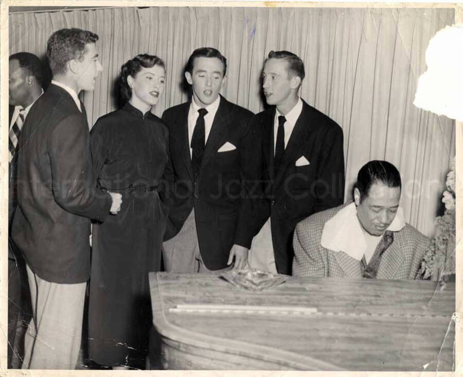 8 x 10 inch photograph. Duke Ellington on piano accompanied by four unidentified singers