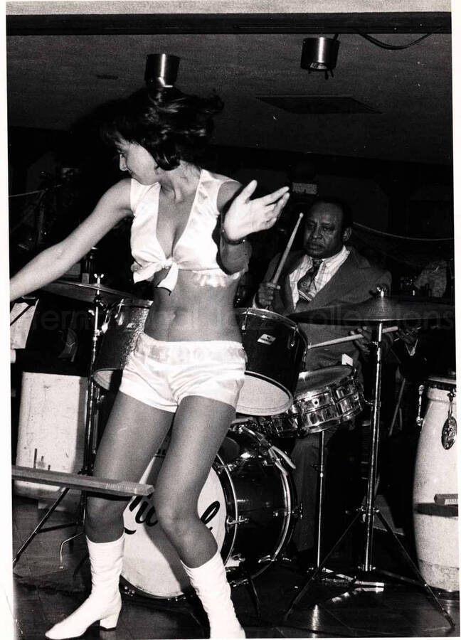 7 x 5 inch photograph. Lionel Hampton on drums with unidentified woman dancing on stage
