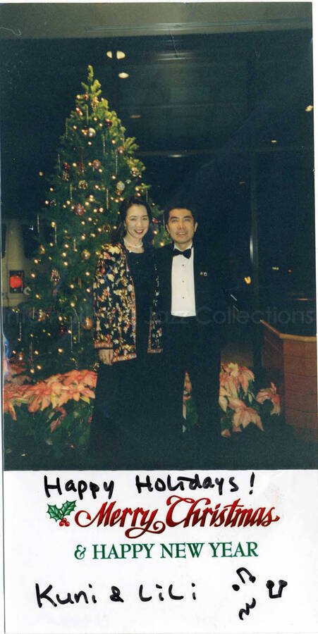 8 x 4 inch photograph. A couple posing in front of a Christmas tree. This photograph has a dedication from Kuni and Lili