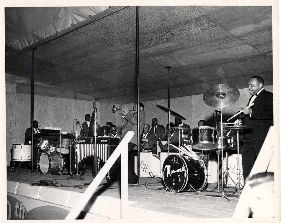8 x 10 inch photograph. Lionel Hampton on drums with band, among which is guitarist Billy Mackel. Stamped on the back of the photograph: USS Lake Champlain CVS-39