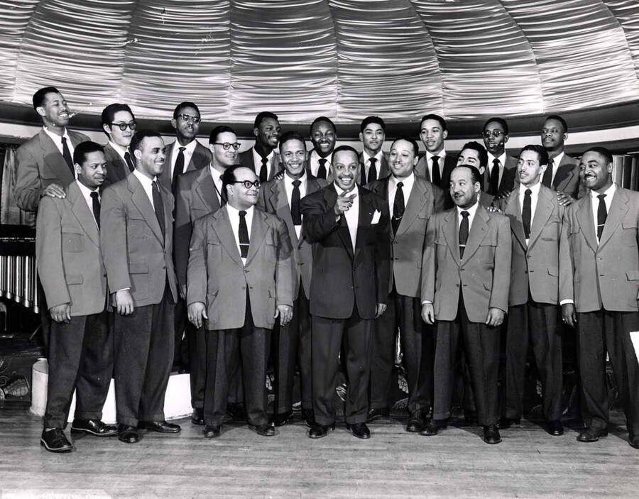 8 x 10 inch photograph. Lionel Hampton's orchestra. Back row from left to right: Al Grey, Paul Higaki, Johnny Board, Al Hayes, Ellis Bartee, Jimmy Cleveland, Benny Powell, Benny Bailey, and Leo Shepherd. Middle row from left to right: Walter Williams, Ben Kenard, Jerome Richardson, Roy Johnson, Bobby Plater, Gil Bernal, Curtis Lowe, and Eddie Mullens.  Front row: Milt Buckner, Lionel Hampton, and William Mackel.