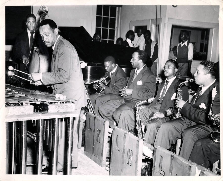 8 x 10 inch photograph. Lionel Hampton on vibraphone with band. From left to right: Roy Johnson (bass), Lionel Hampton, Wes Montgomery (guitar), Johnny Sparrow, Johnny Board, and Bobby Plater.