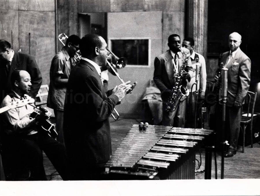 7 x 9 1/2 inch photograph. Lionel Hampton on the vibraphone with band which includes guitarist Billy Mackel