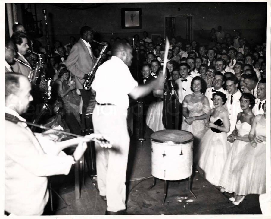 8 x 10 inch photograph. Lionel Hampton on the drums with band and young audience