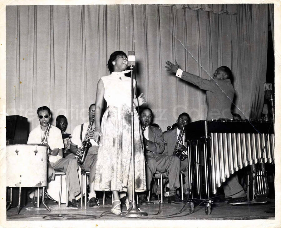 8 x 10 inch photograph. Lionel Hampton on stage with band and unidentified vocalist
