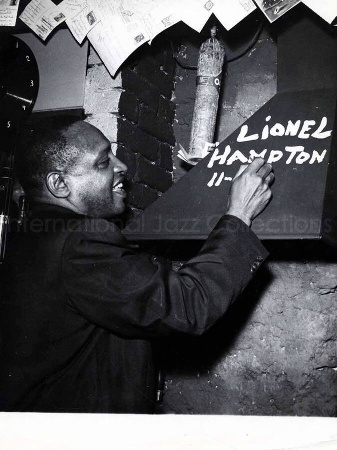 9 1/2 x 7 inch photograph. Lionel Hampton writing his name on a wall [in Versailles, France?]