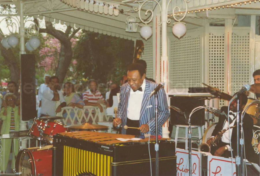 3 1/2 x 5 inch photograph. Lionel Hampton performing on the vibraphone with band [at Disneyland]