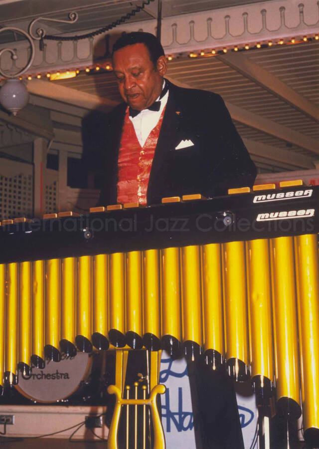 7 x 5 inch photograph. Lionel Hampton performing on the vibraphone with his Big Band [at Disneyland]