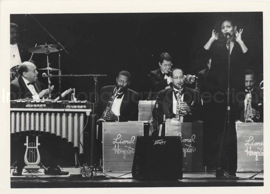 5 x 7 inch photograph. Lionel Hampton with band and unidentified vocalist. [Lionel Hampton's 90th birthday at the Blue Note in New York]