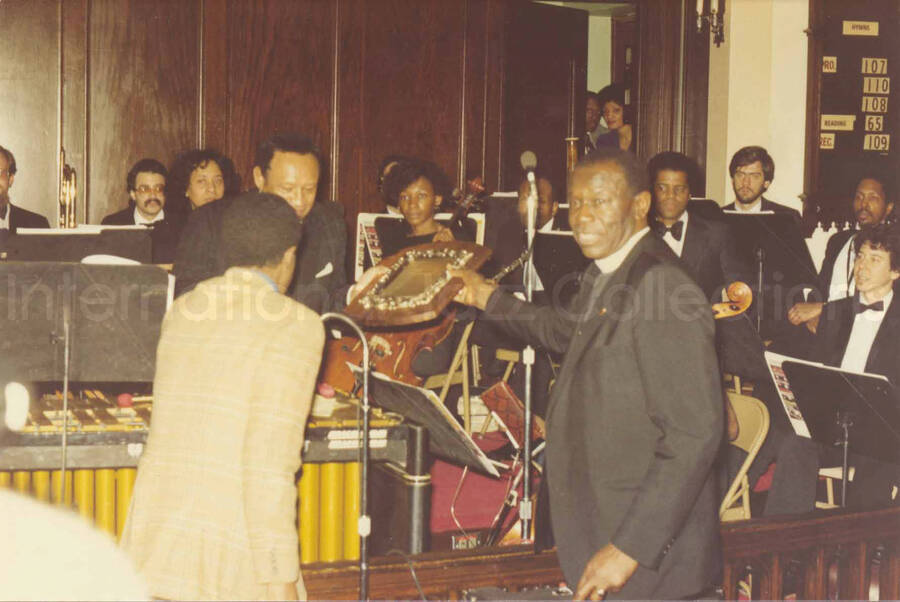 4 x 6 inch photograph. Lionel Hampton receives a plaque from the Mother African Methodist Episcopal Zion Church. Label on the back of the photograph reads: D. P. A. Syndicate, New York, NY