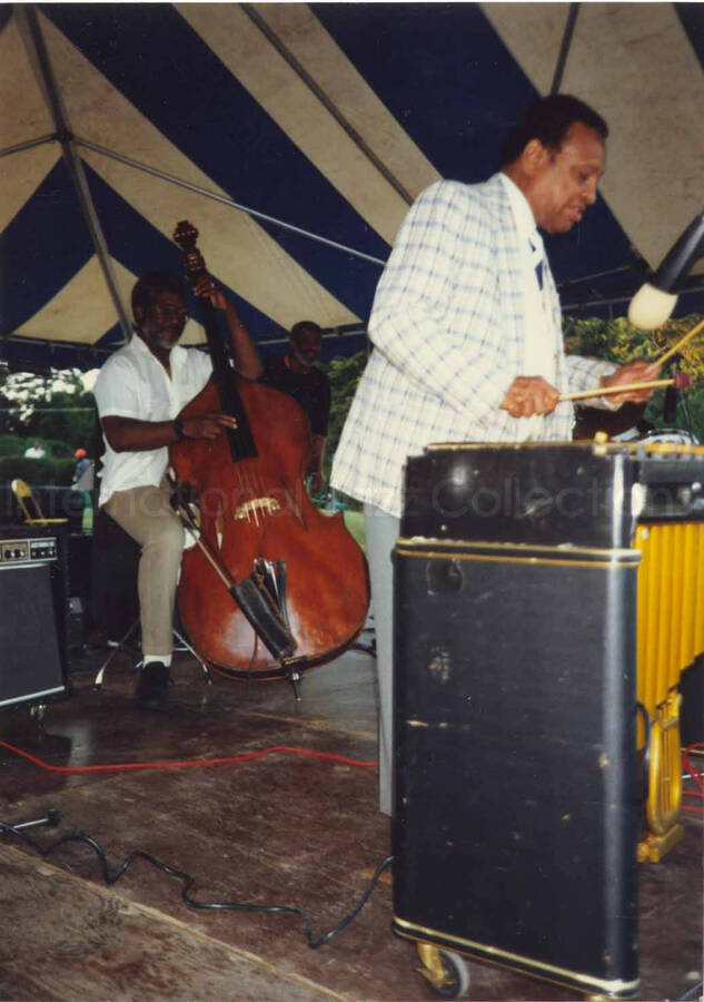5 x 3 1/2 inch photograph. Lionel Hampton on vibraphone under a tent, on the occasion of the Jazzy [Summer jazz festival in Yonkers, NY?]