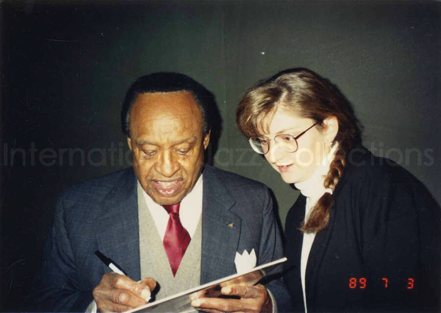 3 1/2 x 5 inch photograph. Lionel Hampton signing autographs