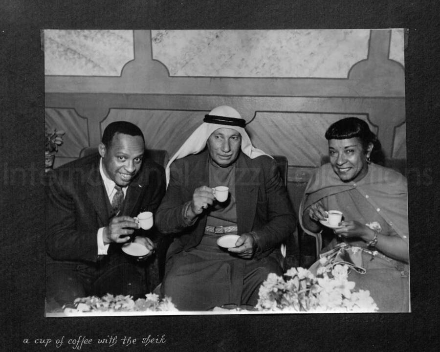 8 x 10 inch photograph. Lionel Hampton in Israel. This photograph is in a photo album titled: In the Holy City - Jerusalem. Caption under the photograph reads: a cup of coffee with the sheik