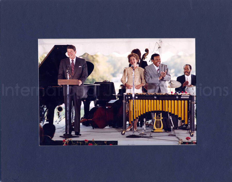8 x 10 inch photograph. Lionel Hampton with President Ronald Reagan and First Lady Nancy Davis Reagan at an outdoor concert at the White House. This concert was aired January 27, 1982 on the public television special, Great Vibes! Lionel Hampton and Friends, as part of the Kennedy Center Tonight series. This photograph is in a 11 x 14 inch black mat